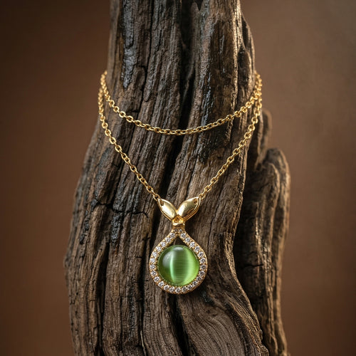 Gold necklace with a green gemstone  mermaid pendant on a wooden surface
